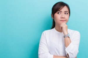 woman contemplating the difference between veneers and bonding in Allen